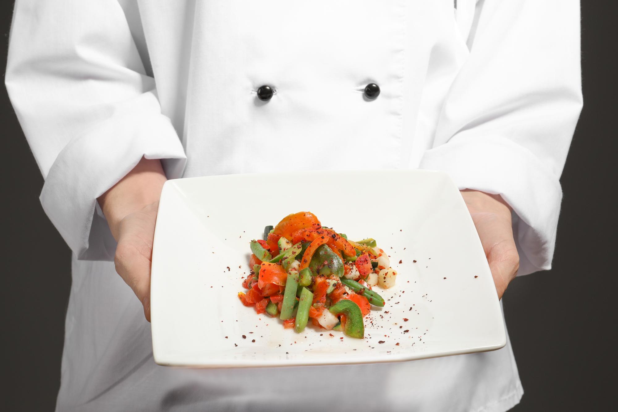 Student plating a modern dish during an online class
